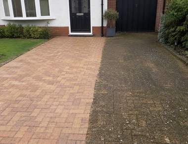 A block paving driveway half cleaned showing the colour difference