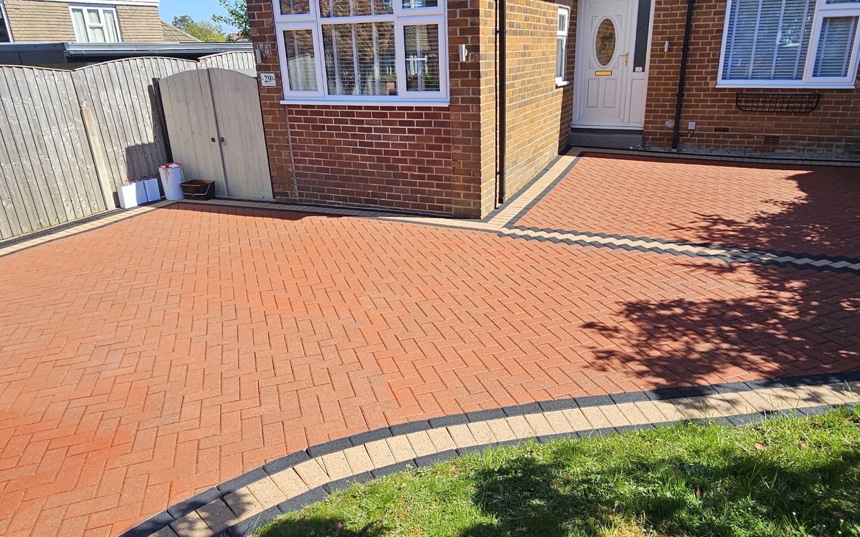A bungalow block paving driveway pressure washed back to a deep red colour