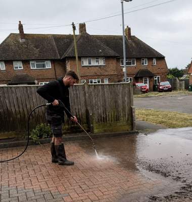 A driveway being pressure washed outside a house