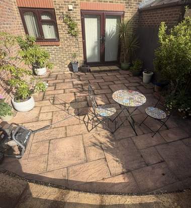 A patio darkened by algae and dirt before cleaning
