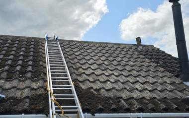 Ladder and pole access set up for a roof clean