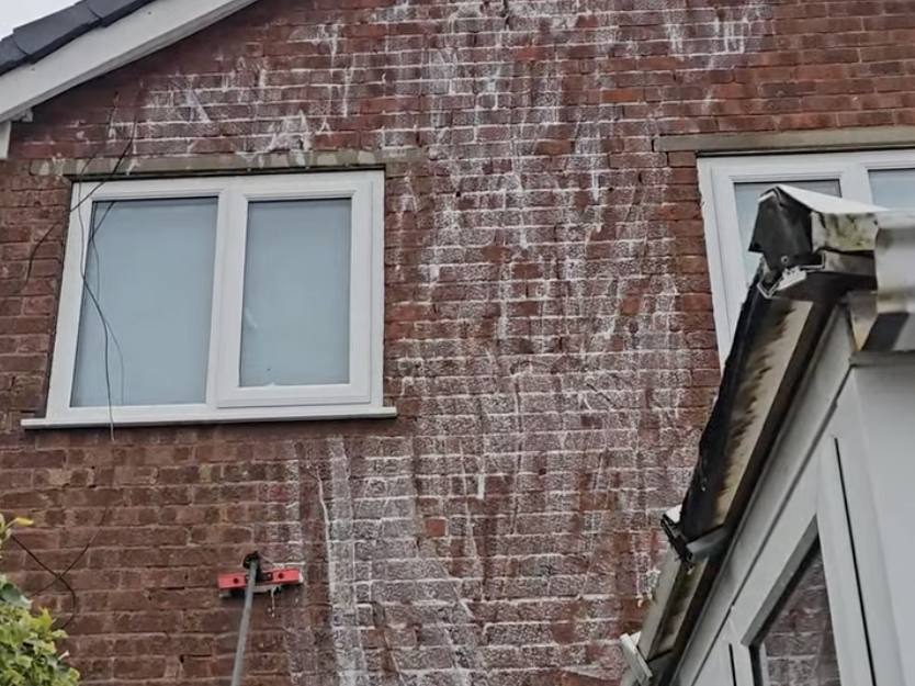 Soft wash treatment running down a stained brick gable